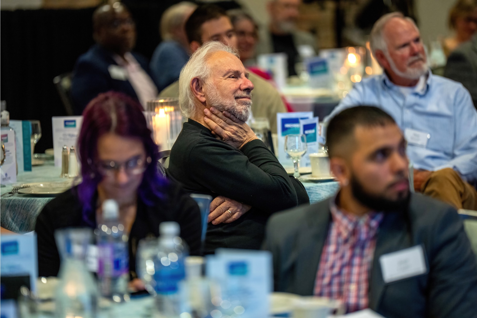 A guest listening from their seat at a table
